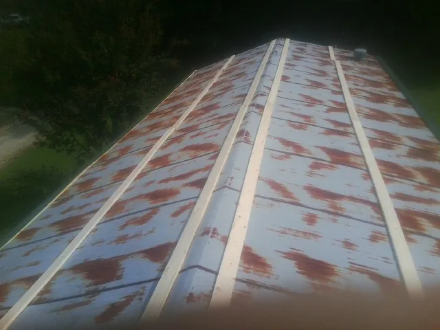 Rusted metal roof panels with new wood purlins before replacement — Storm Damage Roof Repair in Pocahontas by Roofing Brothers