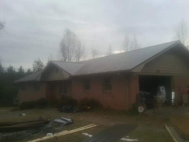 Gray metal roof on a stucco house with an attached garage in Pocahontas