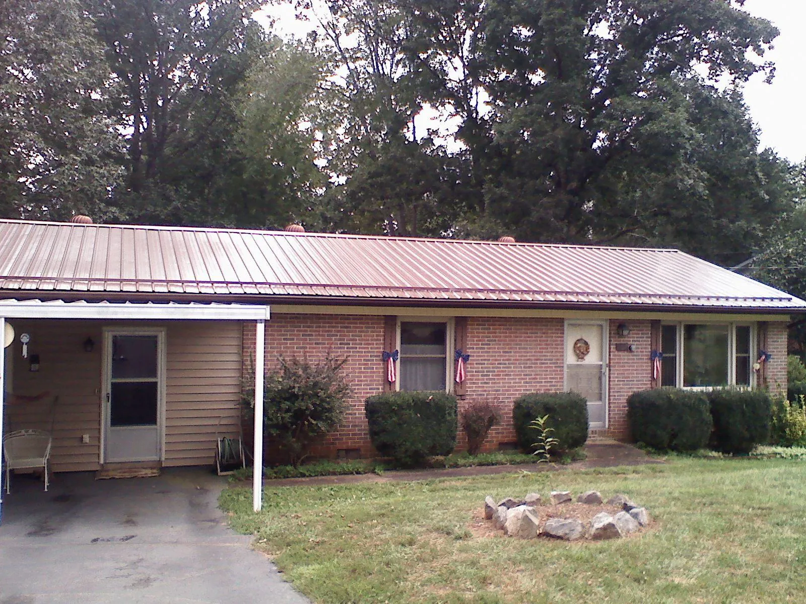 Bronze metal roof and carport on a brick ranch home — Roof Repair work by our crew in Pocahontas